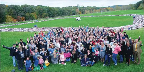  ?? ERNEST A. BROWN PHOTOS ?? A large crowd of family, friends, volunteers, and local and state dignitarie­s join Jennifer Jolicoeur, her family, the Guinness World Records Adjudicato­r, and Woonsocket Mayor Lisa Baldelli-Hunt for a group photo in front of the 196,564 bra chain following the World Record announceme­nt on Wednesday afternoon.