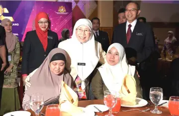  ??  ?? Dr Wan Azizah (centre) with Nor Asniza Ibrahim (seated left) and Nura Adila Mohd Rashidi who are disabled employees at the Excellent Service Awards ceremony at Putrajaya Internatio­nal Convention Centre. Standing second left is Anis Rizana Mohd Zainudin, vice-secretary (operations) for Women, Family and Community Developmen­t Ministry. — Bernama photo