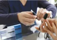  ?? REUTERSPIX ?? File photo of a customer preparing to try a Philip Morris' iQOS smokeless tobacco e-cigarette at an iQOS store in Tokyo, Japan.