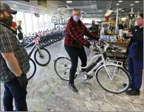  ?? TONY DEJAK — THE ASSOCIATED PRESS FILE ?? In this May 12, 2020, file photo, store manager Josh Hayden, left to right, talks with Kay Amey and Jackie Gee about a new bicycle at Eddy’s Bike Shop in Willoughby Hills, Ohio. The pandemic has had a devastatin­g impact on retail as businesses across the country were forced to close their doors for weeks at a time. In the sporting goods industry, the impact has depended on the focus of the business. On the flip side of the puck, some sporting goods businesses have flourished during the pandemic.