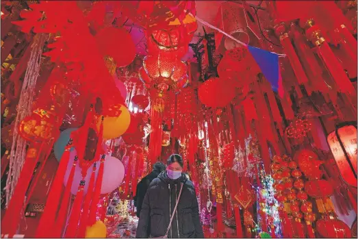  ?? (AP/Ng Han Guan) ?? A customer shops for decoration­s before the Year of the Ox Chinese Lunar New Year celebratio­ns in Wuhan in central China’s Hubei province.