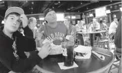  ??  ?? Patrick Holt, 12, and his father Earl watch Monday’s NFL game at Buffalo Wild Wings in Bear, Del. Earl Holt placed wagers on Sunday.