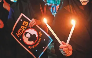  ?? AFP ?? Burqa-clad women take part in a protest in Kolkata against directives issued by Karnataka’s government barring students in government-run high schools from wearing hijab.