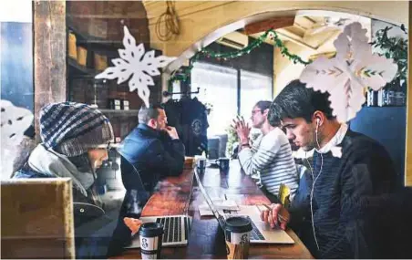  ?? New York Times ?? Customers on their computers in the Laptop Room of the Sweetleaf cafe in New York. Remote workers with laptops have staked out coffee shops for years, but their ranks are rising.