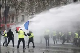  ?? KAMIL ZIHNIOGLU — THE ASSOCIATED PRESS ?? Police operate a water cannon during clashes with demonstrat­ors, called the yellow jackets, in Paris as they protest Saturday against rising fuel taxes in France.