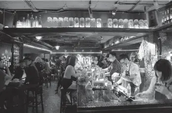  ?? ASHLEY PON/THE NEW YORK TIMES ?? Patrons pack a bar Friday in Taiwan’s capital city of Taipei. The relatively few people allowed to enter the country during the coronaviru­s pandemic have been coming in droves, helping to fuel an economic boom.