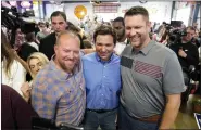  ?? ASSOCIATED PRESS FILE PHOTO ?? Florida Gov. Ron DeSantis, center, poses for a photo with audience members during a fundraisin­g picnic for Rep. Randy Feenstra, R-Iowa, on May 13in Sioux Center, Iowa.