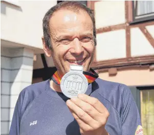  ??  ?? Voller Stolz präsentier­t Siegfried Anhorn seine Medaille (Bild links), die er beim Berlin-Marathon (Bild rechts) errungen hat.