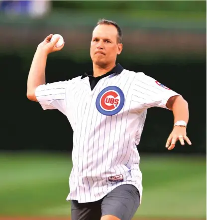  ??  ?? Northweste­rn coach Chris Collins, a longtime Cubs fan, throws out a ceremonial first pitch last season at Wrigley Field. | AP