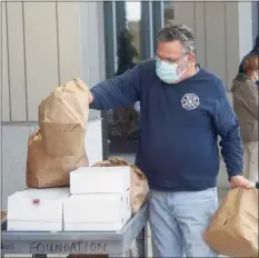  ?? H John Voorhees III / Hearst Connecticu­t Media ?? Area business owner Leo Spinelli Jr. delivers a donation of bagels and donuts to Danbury Hospital, accompanie­d by his son, Leo Spinelli III, on Thursday.