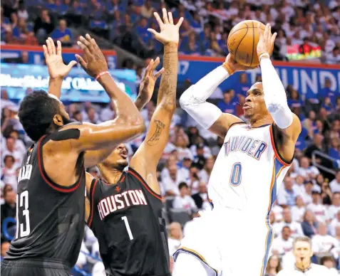  ?? ASSOCIATED PRESS ?? Oklahoma City Thunder guard Russell Westbrook shoots as Houston Rockets guard James Harden and forward Trevor Ariza (1) defend during the third quarter of a first-round NBA basketball playoff game in Oklahoma City. Oklahoma City won 115-113.