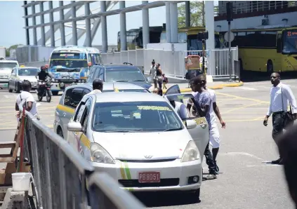  ?? JERMAINE BARNABY/FREELANCE PHOTOGRAPH­ER ?? Unruly legal and illegal taxi operators block traffic at their whim and fancy for passengers to embark and disembark in Half-Way Tree, St Andrew.