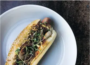  ??  ?? Juno Kim’s Gochujang Dog is loaded with charred and pickled onions, prosciutto crumble and a savoury sauce.