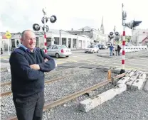  ?? PHOTO: DANIEL BIRCHFIELD ?? Call to arms . . . Oamaru Steam and Rail Society general manager Harry Andrew observes traffic on Humber St crossing the rail line owned by the society, which runs its dieselpowe­red train from Harboursid­e Station every Sunday.