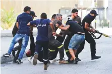  ?? Reuters ?? Protesters evacuate a victim after gunfire erupted in Beirut during a Hezbollah rally against judge Tarek Bitar yesterday.