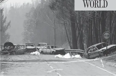  ?? ARMANDO FRANCA / THE ASSOCIATED PRESS ?? Burned-out cars line the road between Castanheir­a de Pera and Figueiro dos Vinhos, central Portugal, on Sunday after flames from a large-scale forest fire swept over the area, killing scores of people.