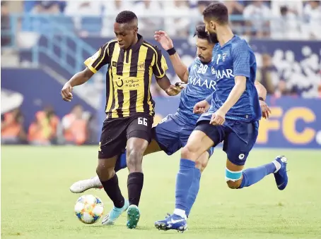  ?? AFP ?? Al-Hilal midfielder Salem Al-Dawsari vies for the ball with Al-Ittihad defender Saud Abdulhamid, left, during their AFC Champions League quarterfin­als match.