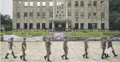  ?? Picture: AFP ?? DAYS GONE BY. South Korean soldiers walk past the former North Korean Workers Party headquarte­rs in Cheorwon.