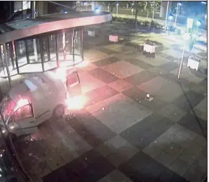  ?? — Reuters ?? A deliberate act: A screengrab from a video showing a burning van and a person running (top right) after crashing into the glass facade of the ‘De Telegraaf’ head office in Amsterdam.