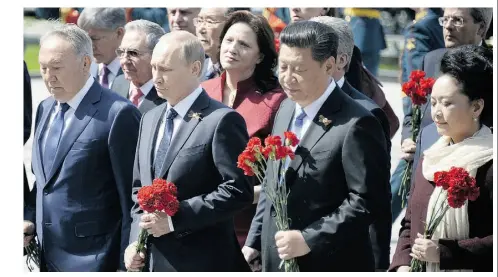  ?? AesLEXANDE­R NEMENOV/AFP/Gtty Image ?? Russian President Vladimir Putin is flanked by Kazakh President Nursultan Nazarbayev, left, and Chinese President Xi Jinping and his wife Peng Liyuan during a ceremony Saturday at the Tomb of the Unknown Soldier in Moscow.