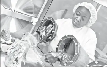  ??  ?? Andrea Mosie, Apollo sample processor, handles samples inside their airtight containers at the Lyndon B. Johnson Space Centre in Houston. — Photo for The Washington Post by Spike Johnson