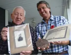  ?? PETER LEE/WATERLOO REGION RECORD ?? Bill Haber and his father, Don, hold a photograph, memorial plaque and death certificat­e related to their ancestor, Pte. Frank Angus McKinnon, whose death in Belgium was noted in the Brantford Expositor, left, 100 years ago.