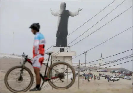  ?? MARTIN MEJIA — THE ASSOCIATED PRESS ?? A man rests with his bicycle near the Cristo del Pacifico (Christ of the Pacific) statue in Lima, Peru, on Saturday. The replica of the Christ the Redeemer Statue in Rio de Janeiro was set on fire days before Pope Francis is scheduled to arrive in the...