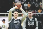  ?? AP PHOTO/RICK BOWMER ?? Denver Nuggets Nikola Jokic shoots as Dallas Mavericks Luka Doncic (right) looks on during NBA All-Star basketball practice on Saturday in Salt Lake City.