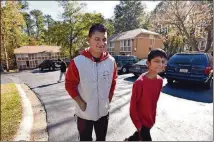  ?? HYOSUB SHIN / HSHIN@AJC.COM ?? Ryan and his brother Basan, 11, take a walk around their apartment complex in Clarkston.