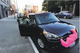  ?? Ted S. Warren / Associated Press ?? Katie Baranyuk gets out at the end of her Lyft ride provided by Dara Jenkins.