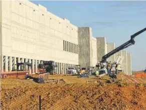  ??  ?? Crews work on new developmen­t along I-25 at the future Amazon fulfillmen­t center ,which set to open in Thornton in 2018.