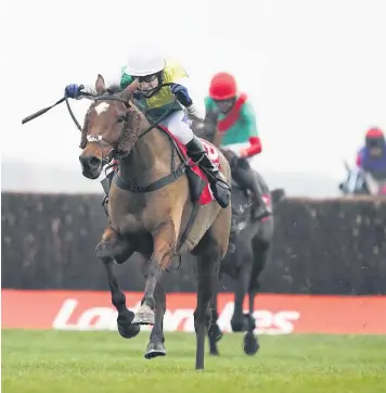  ??  ?? Cloth Cap ridden by Tom Scudamore strides away from the last to win The Ladbrokes Trophy Chase at Newbury