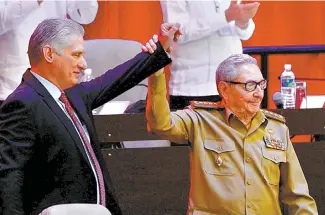  ?? AFP-Yonhap ?? A photo released by Cuban News Agency (ACN) shows the outgoing First Secretary of the Cuban Communist Party (PCC), Raul Castro, right, raising Cuban President Miguel Diaz-Canel’s hand as he was elected as the new First Secretary during the 8th Congress of the Cuban Communist Party at the Convention Palace in Havana, Monday.