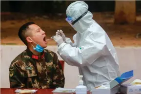  ??  ?? NUCLEIC ACID TEST Nangongole­kta ang medical staff sa Shenzhen, China ng samples mula sa Chinese paramilita­ry police officers para suriin sa COVID-19 virus. AFP