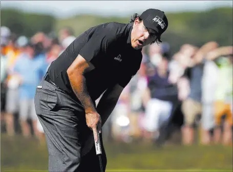  ?? Seth Wenig ?? Phil Mickelson’s expression says he misses a putt on the 14th green on his way to shooting a first-round 77. The Associated Press