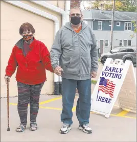  ?? Geoff Mulvihill The Associated Press ?? Tim and Pat Tompkins pause for a picture Friday on their way to early vote in Bettendorf, Iowa. Tompkins said he and his wife, Pat, were concerned about coronaviru­s exposure in bigger crowds and brought their own sanitizer, but were determined to vote.