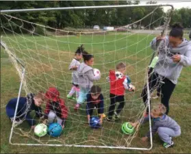  ?? RICHARD PAYERCHIN — THE MORNING JOURNAL ?? Lorain Youth Soccer Associatio­n Junior Vice President Danielle Santos lifts up the practice goal as players retrieve their soccer balls at the league’s home fields behind Horizon Science Academy, 760 Tower Blvd. The associatio­n this fall had about 230 youths playing on multiple in-house and traveling teams.