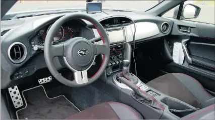  ??  ?? The BRZ’S cockpit is dressed in decent soft-touch materials and good-looking gauges, aluminum pedals and a proper centre-mounted tachometer, much like the way Porsche does it.