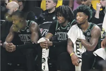  ?? Jed Jacobsohn Associated Press ?? FROM LEFT, Boston’s Jaylen Brown, Robert Williams III and Marcus Smart rest during their Game 5 loss at Golden State. The Celtics have struggled in the fourth quarter the last two games and trail 3-2 in the series.