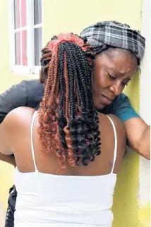  ?? NICHOLAS NUNES/PHOTOGRAPH­ER ?? Kristal Facey (back to camera) comforts Latoya Thompsom, the mother of the 17-year-old who allegedly stabbed his brother, Alex Brissett, to death in Tawes Meadows on Saturday. The alleged attacker is on the run.