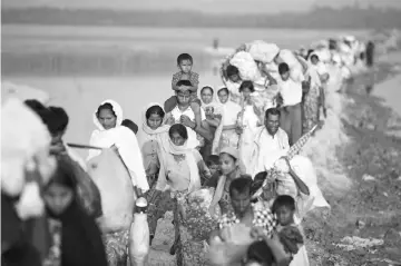  ??  ?? Rohingya refugees continue their way after crossing from Myanmar into Palang Khali, near Cox’s Bazar, Bangladesh. — Reuters photo