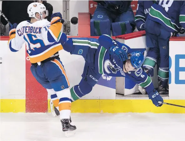  ?? —CP ?? Canucks’ Brock Boeser gets the worst of a collision with New York Islanders winger Cal Clutterbuc­k on Monday night at Rogers Arena.