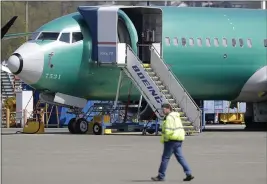  ?? TED S. WARREN — THE ASSOCIATED PRESS FILE ?? A worker walks past a Boeing 737Max 8airplane at Boeing’s assembly facility in Renton, Wash.