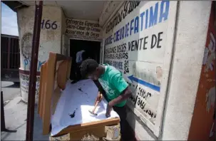  ?? The Associated Press ?? UPHOLSTERY: Jean Pierre Mercelien upholsters the inside of a coffin at a shop in downtown in Port-au-Prince, Haiti.