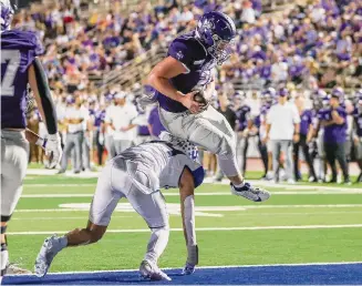  ?? Photos by Marvin Pfeiffer/Staff Photograph­er ?? Boerne's Hutson Hendrix leaps over Somerset's Samuel Calzadilla­s for a 1-yard touchdown during the second half of Friday night's 31-7 victory at Boerne ISD Stadium.