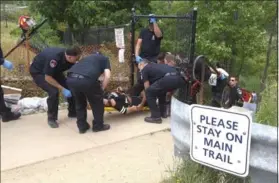  ??  ?? Emergency crews assist an injured person at Albion Falls Sunday.