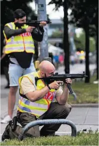  ??  ?? Police officers take aim on the streets of Munich