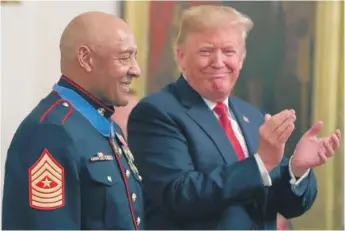  ?? MARK WILSON/GETTY IMAGES ?? President Donald Trump presents the Medal of Honor for actions in 1968 to retired Marine Sgt. Major John Canley during a ceremony in the East Room of the White House on Wednesday.