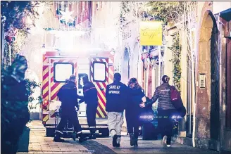  ?? (AFP) ?? Emergency workers escort a woman after a shooting near the Christmas market in Strasbourg, eastern France onDec 11.