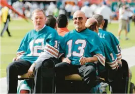  ?? JOHN BAZEMORE/AP ?? Bob Griese (12) and Jake Scott (13), of the 1972 Miami Dolphins ride in a golf cart during festivitie­s to honor the team in 2012.